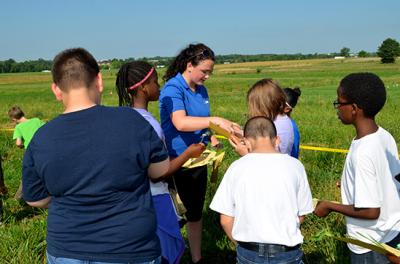 Sydney Beidleman, center, UK forage intern, helps Millcreek Elementary students identify weeds.