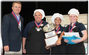 Agriculture Commissioner James Comer presents the winning trophy in the Farm to School Junior Chef competition to the Mayfield High School team: from left, Jade Gowins, Aolani Madera, and Morgan Newell. (Kentucky Department of Agriculture photo by Chris Aldridge)